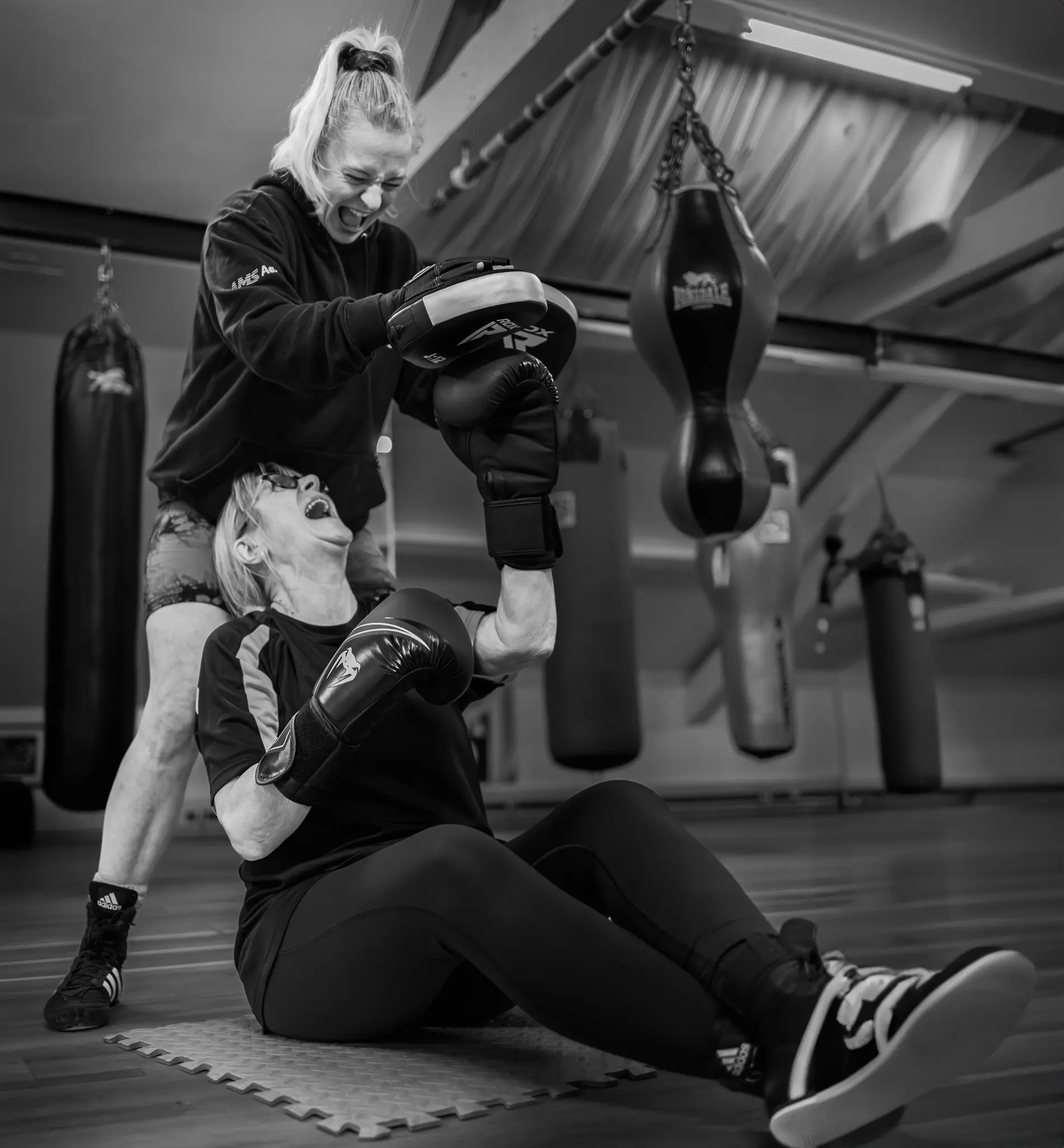 Ladies Partner Conditioning West Oxon Boxing Two women in boxing gloves performing synchronized core conditioning drills at West Oxon Boxing & Fitness in Witney.